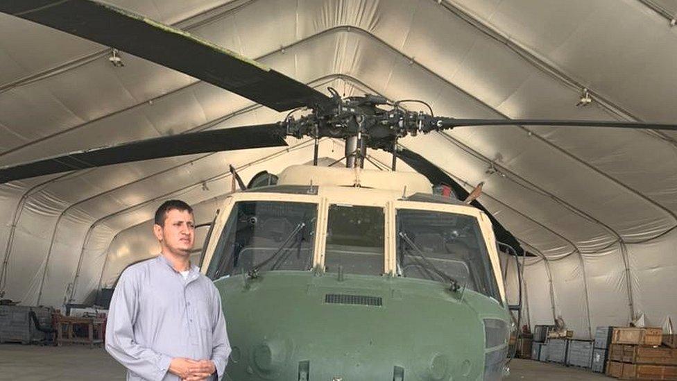 Momand in front of his helicopter inside a hanger - photo taken August 2022