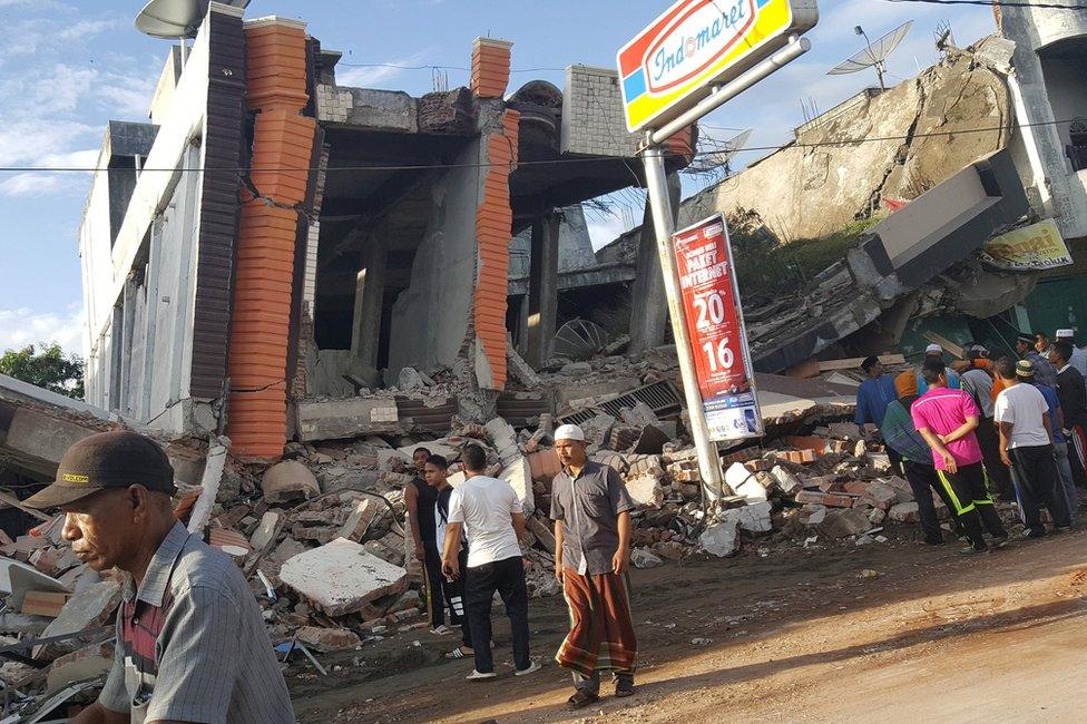 People survey the damage after dozens of buildings collapsed following a 6.4 magnitude earthquake in Ule Glee, Pidie Jaya in the northern province of Aceh, Indonesia 7 December 2016.