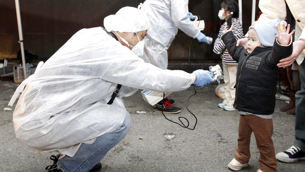 A child being screened for radiation following the Fukushima nuclear disaster