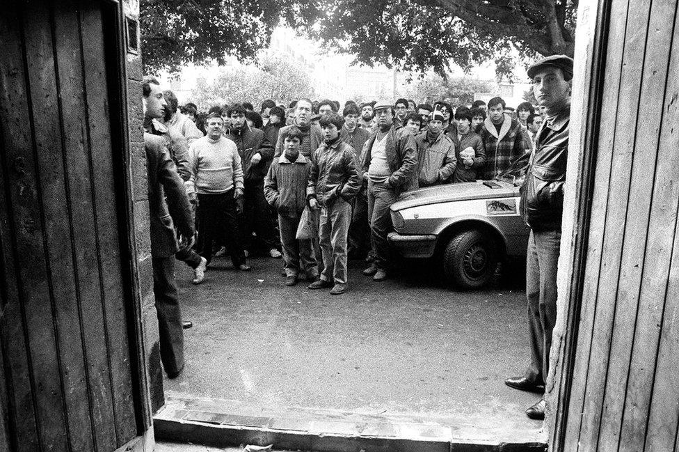 Crowd outside the building in piazza Sant'Oliva where a triple homicide has been committed, Palermo, 1982