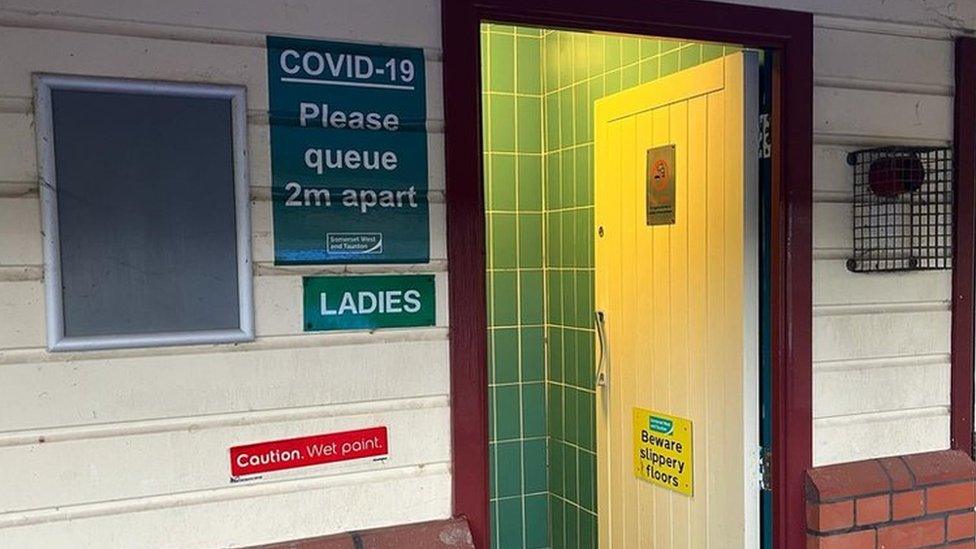 Wooden toilet doors in a brick and wood wall