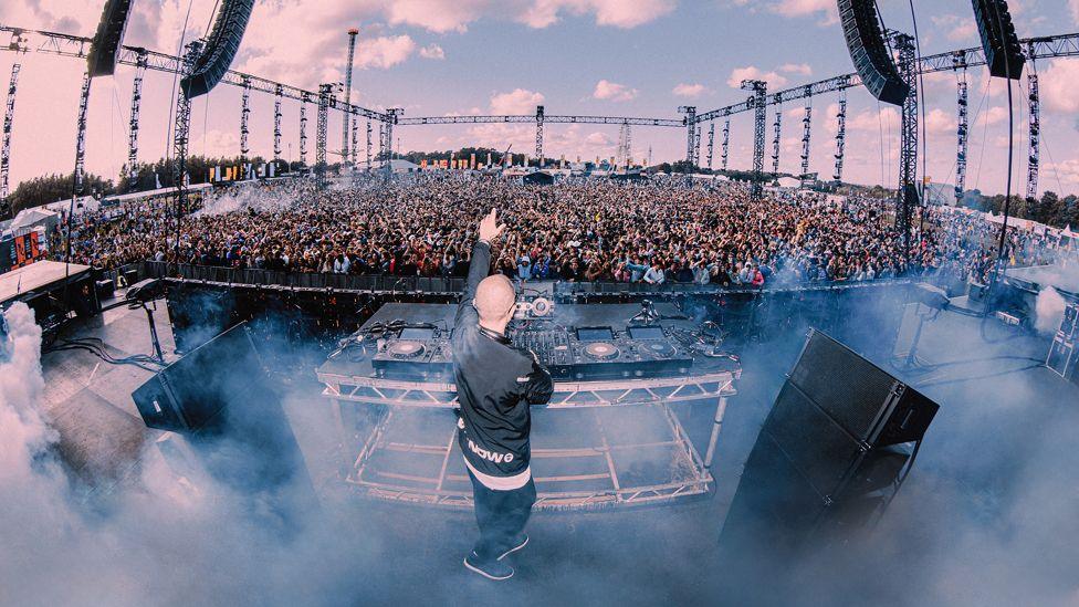 A performer signals to the crowd from the stage at Parklife 