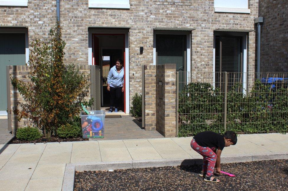 A mother watches as her son plays in the front garden