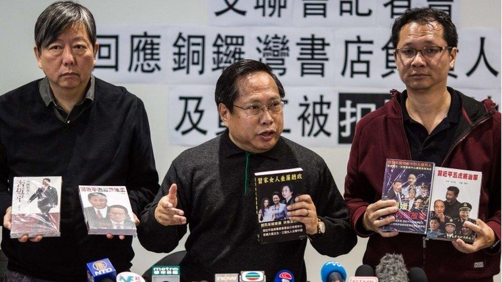 Pro-democracy group members Lee Cheuk Yan (2nd L), Albert Ho (C) and Richard Tsoi (4th L) hold up books during a press conference over the disappearance of five publishers in Hong Kong on January 3, 2016,