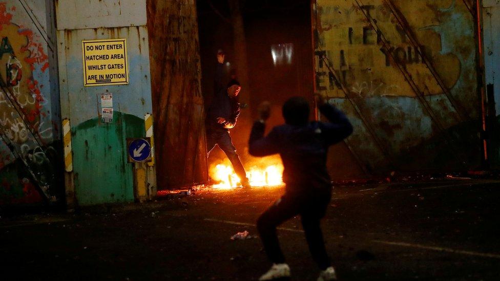 Protesters are seen at the "peace wall" gate into Lanark Way as protests continue in Belfast, Northern Ireland