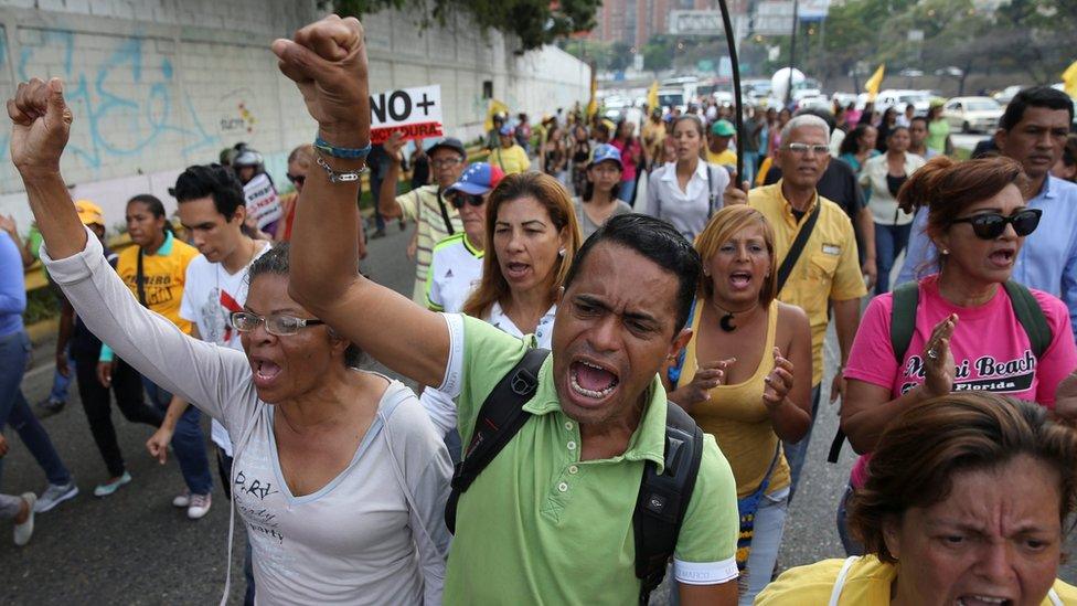 Opposition supporters shout slogans as they block a highway during a protest against Venezuelan President Nicolas Maduro"s government in Caracas