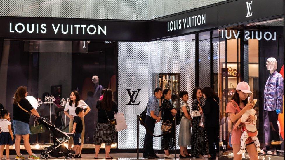 People queue up outside the Louis Vuitton store at a mall in Shenzhen, China