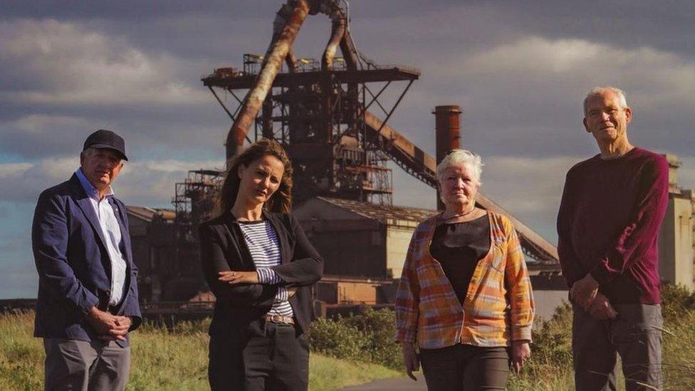 Four members of the Save our Steel Heritage group standing in front of the blast furnace