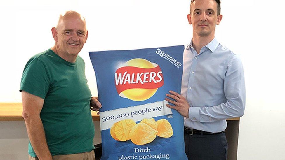 Campaigner Geraint Ashcroft (l) meets Duncan Gordon from Walkers' owner PepsiCo to present a "ditch the plastic" giant Walkers crisp packet