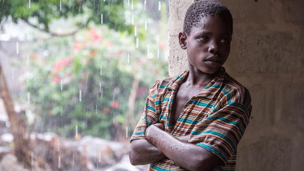 Boy sheltering from the rain