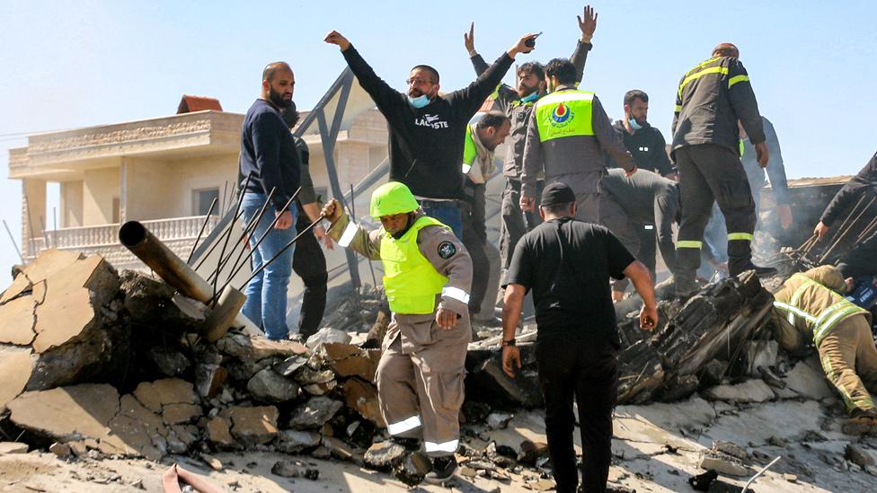 Lebanese civil defence members search the rubble of a destroyed building in the aftermath of an Israeli airstrike on the village of Sarein, near Baalbek in east central Lebanon on March 12, 2024.