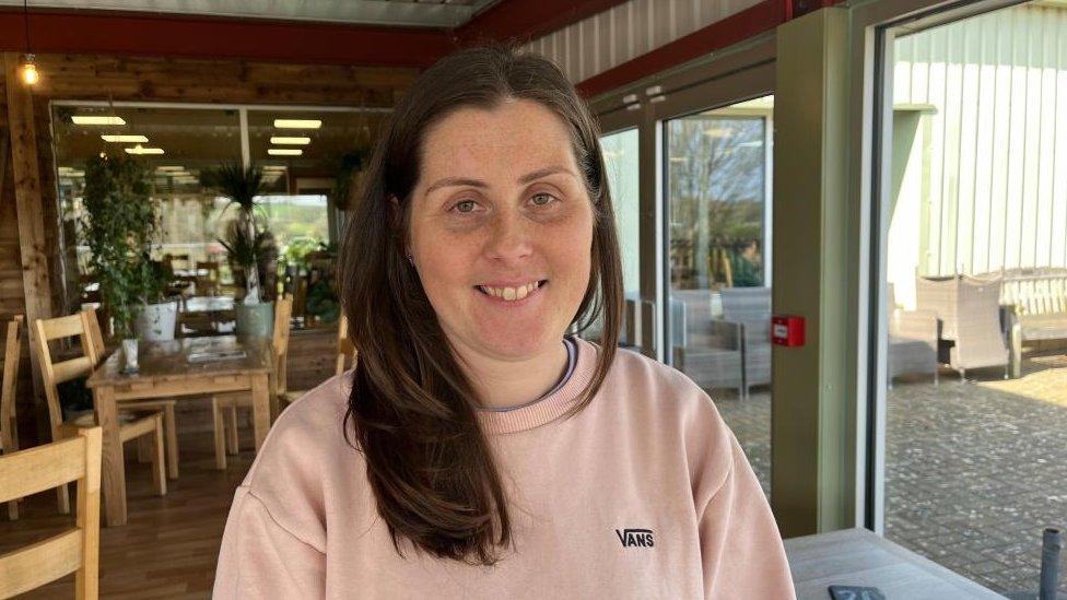 Ashleigh Loach with long straight dark hair in a garden centre