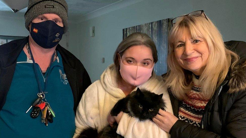 Millie the cat with her owners