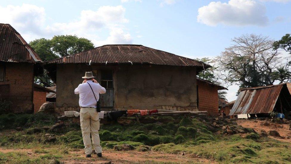 A Judge takes picture, to be used as evidence, in the northern Liberian village of Kortuhum