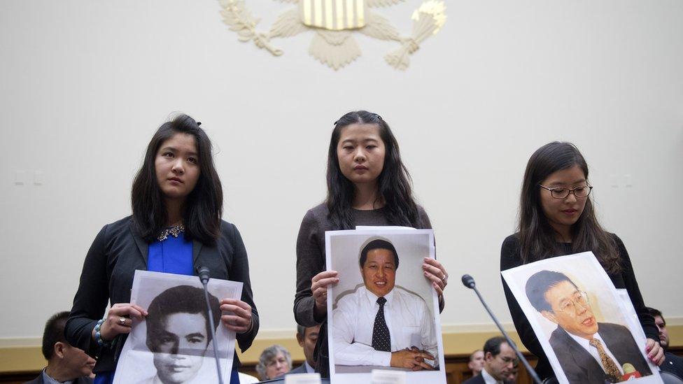 From left, Lisa Peng, daughter of Peng Ming, Grace Ge Geng, daughter of Gao Zhisheng, and Ti-Anna Wang, daughter of Wang Bingzhang, hold pictures of their imprisoned fathers