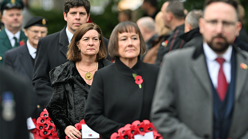 Dignitaries hold wreaths to be placed at the national memorial