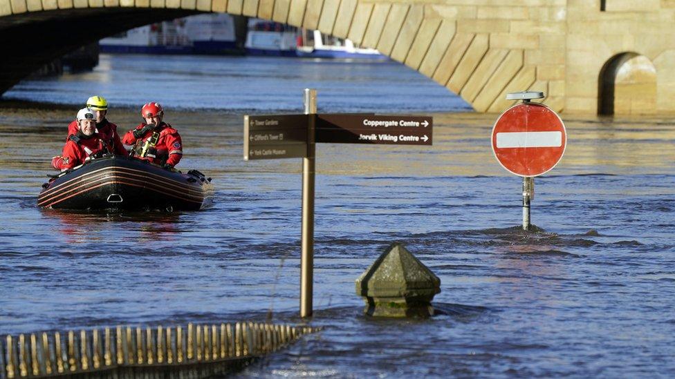 Rescue workers use a boat to navigate the floodwater in the centre of York after the River Ouse burst its banks.