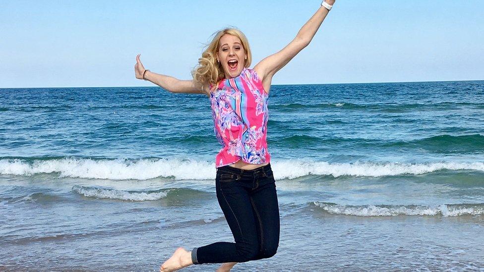 Victoria leaps into the air in front of the ocean