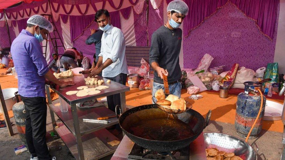 Farmers cook lunch along a street as they continue a demonstration to protest against the recent agricultural reforms at the Delhi-Uttar Pradesh state border in Ghazipur on December 7, 2020.