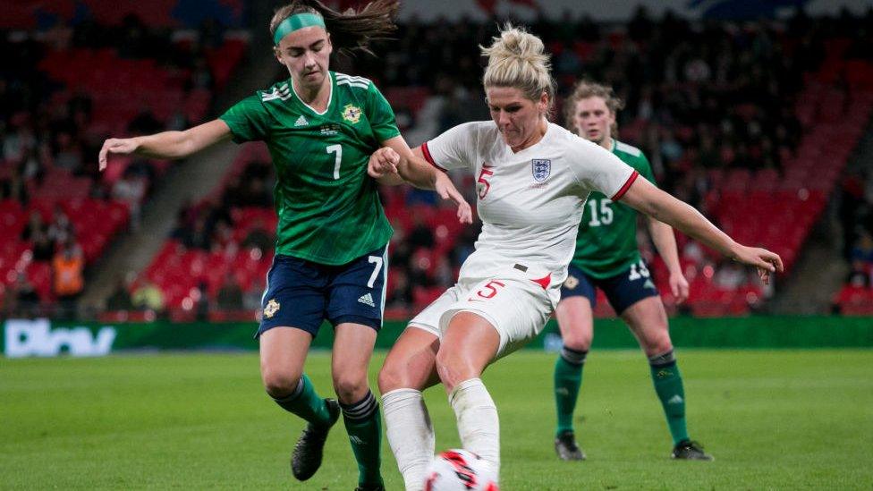 Northern Ireland and England players battle for ball.