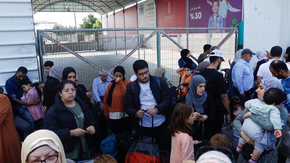 Palestinians with dual citizenship gather outside Rafah border crossing with Egypt in the hope of getting permission to leave Gaza