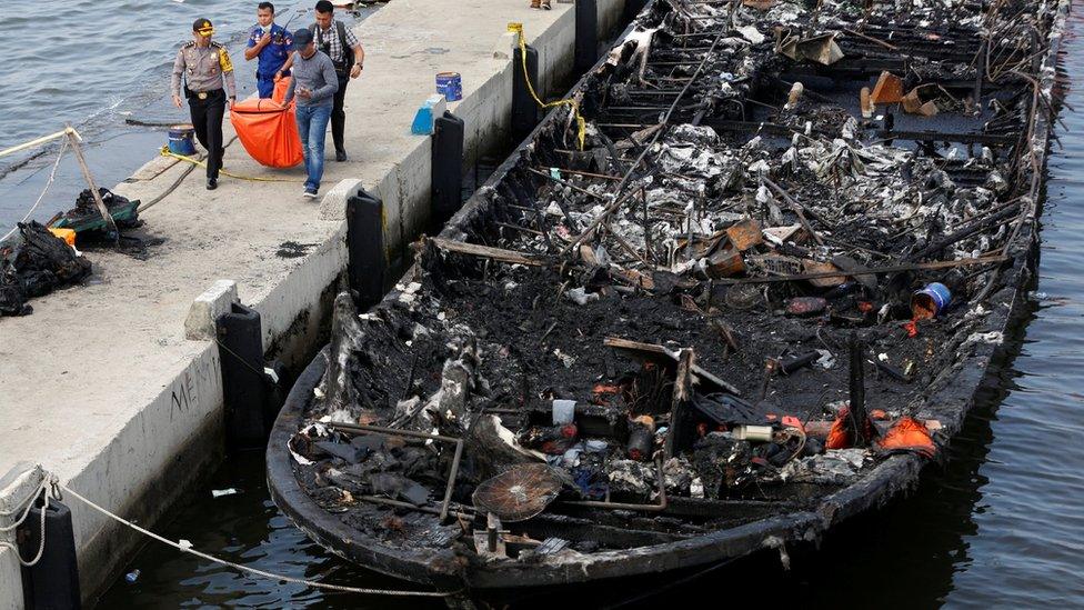 The remains of a victim is carried away after a fire ripped through a boat carrying tourists to islands north of the capital, at Muara Angke port in Jakarta, Indonesia on 1 January 2017