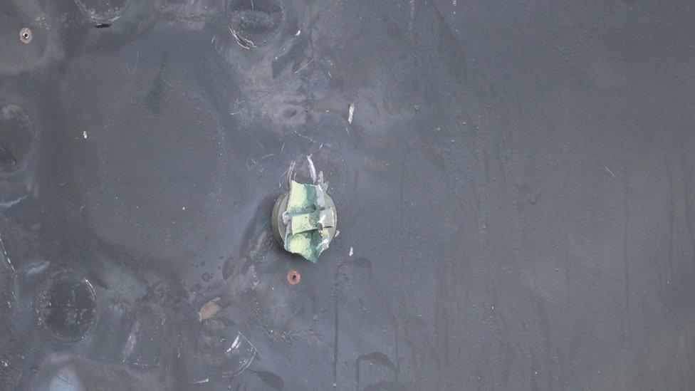 US Department of Defense: This is the view of the remnants of a removed limpet mine’s placement, location, and damage sustained from a limpet mine attack, on the starboard side of motor vessel M/T Kokuka Courageous, while operating in the Gulf of Oman, June 13. A limpet mine is attached to a vessel via magnet and/or nails. The holes seen were created by nails used to hold the mine in place.