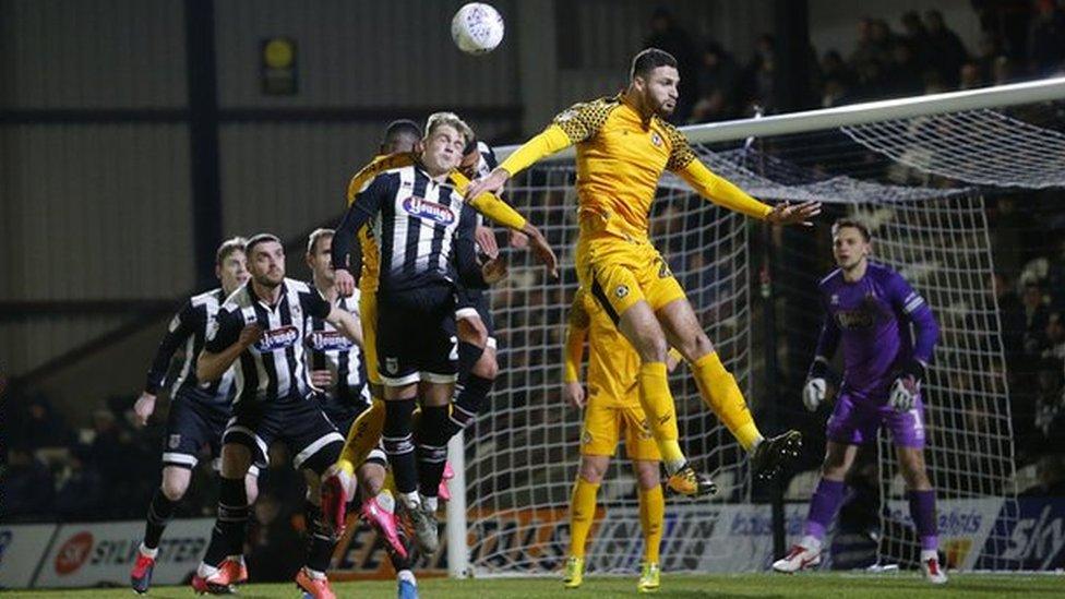 Ryan Inniss of Newport County rises to meet a corner