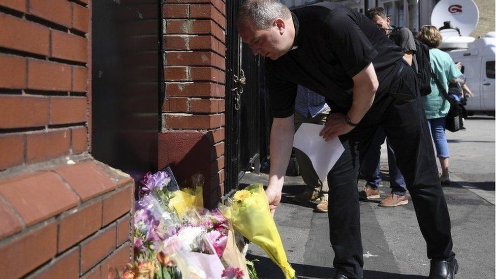 A priest leaves flowers at the scene of a terror attack in Finsbury Park