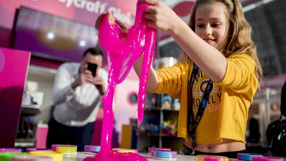 A girl playing with pink slime