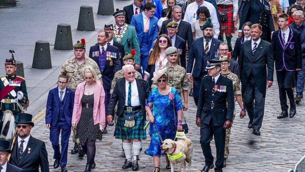 People process towards the cathedral, some wearing Scottish national dress