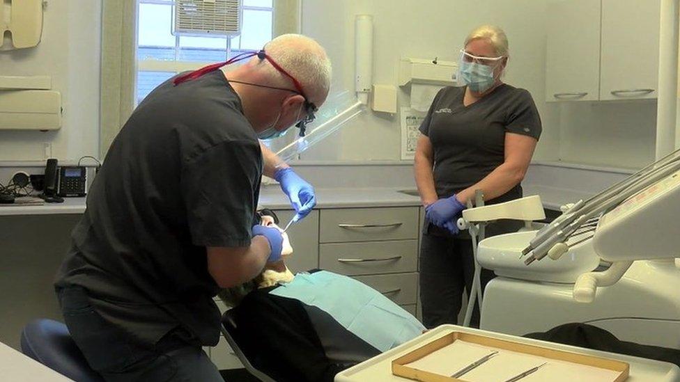 Dentist, nurse and patient receiving treatment