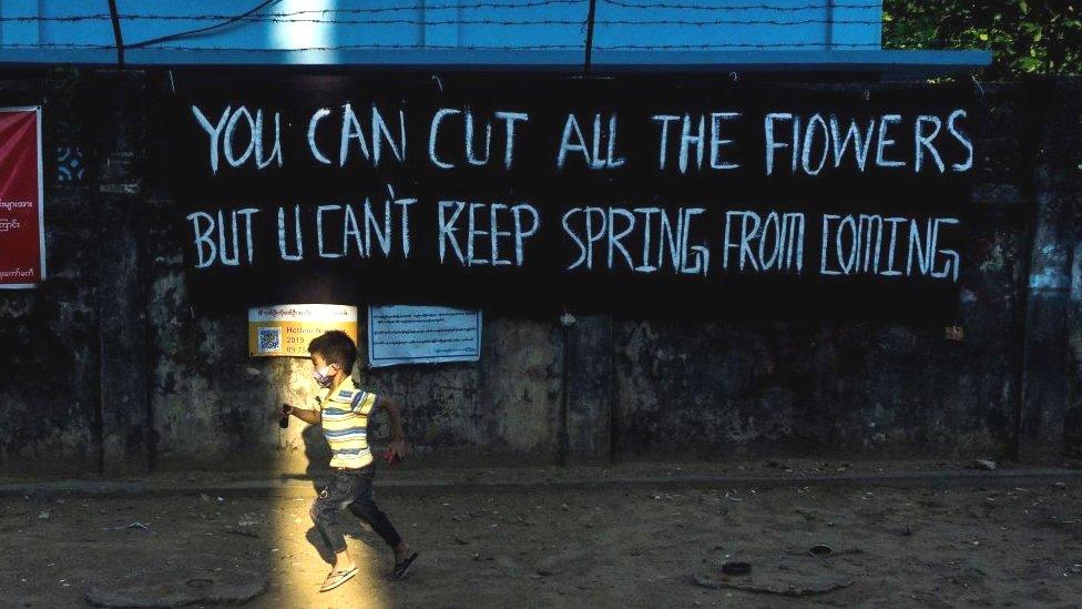 A child plays next to a banner put up by activists