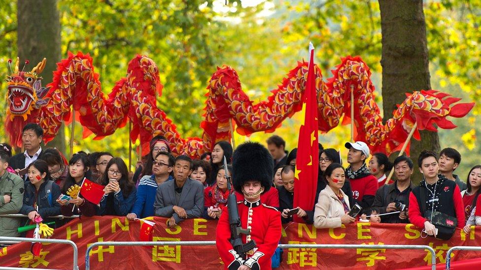 Pro-China supporters perform a dragon dance behind a Queen's Guard during