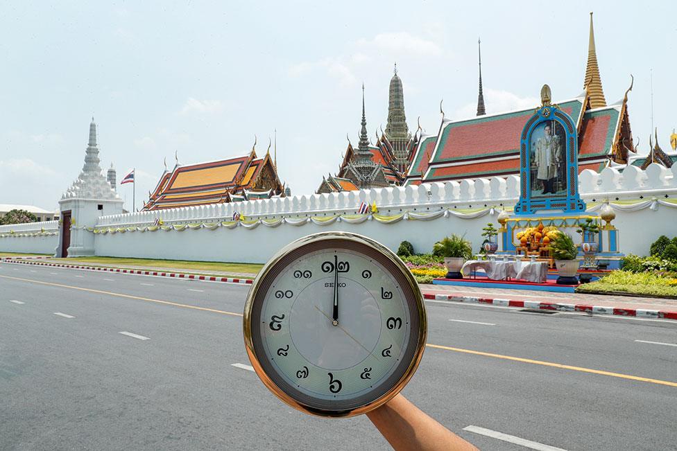 A clock showing the time at noon at Wat Phra Si Rattana Satsadaram (The Temple of the Emerald Buddha, also known as The Grand Palace) in Bangkok, Thailand