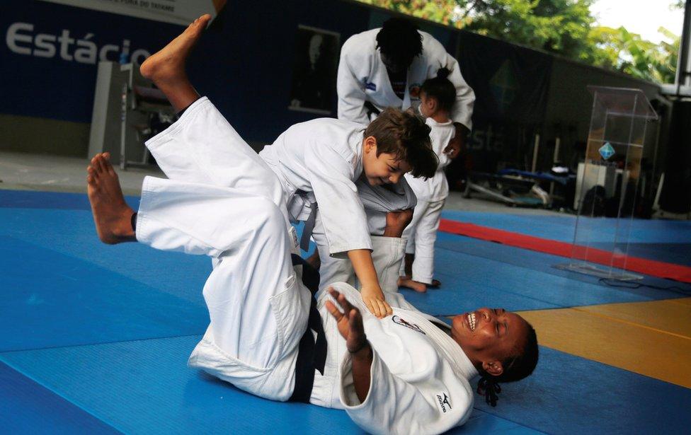 Judo athlete Yolande Bukasa, a refugee from Democratic Republic of Congo, performs with a kid during a news conference where she was announced as part of the refugee athletes qualified for the 2016 Rio Olympics in Rio de Janeiro, Brazil, June 3, 2016.