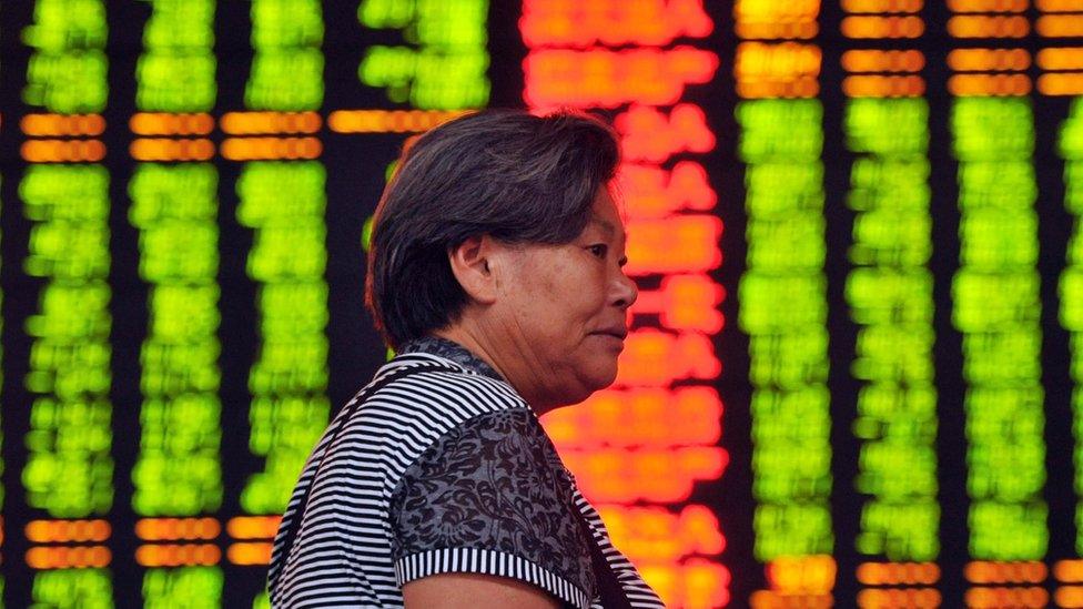 Investor in front of share price screens in China