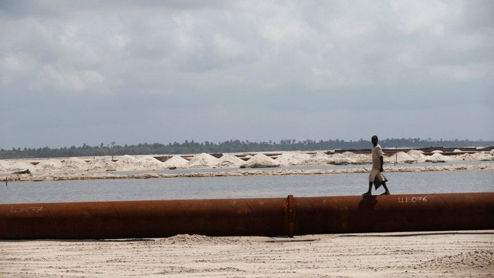 A man walks on a pipeline running through the proposed Dangote oil refinery site near Akodo beach in the outskirt of Nigeria"s commercial capital Lagos June 25, 2016.