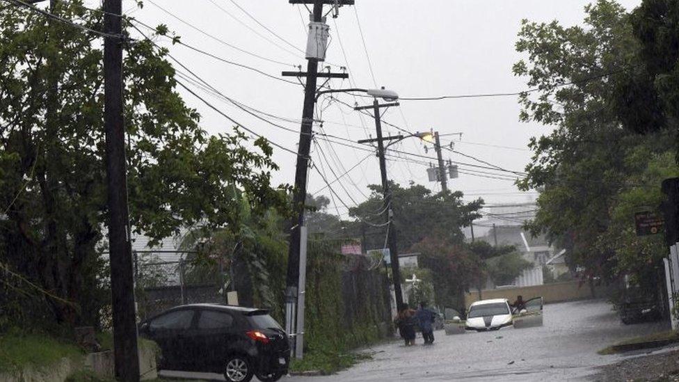 A car tries to cross a flooded street in downtown Kingston Jamaica (02 October 2016)