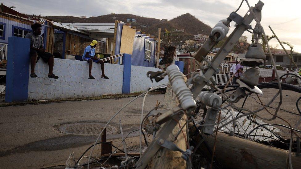 Residents look at downed power lines on British Virgin Islands