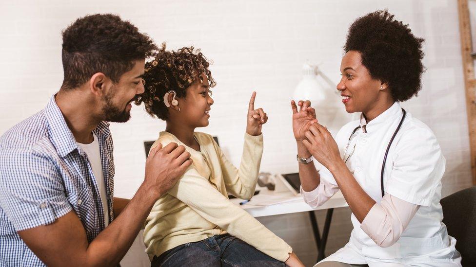 boy-communicating-with-family-using-BSL-and-hearinga-aids