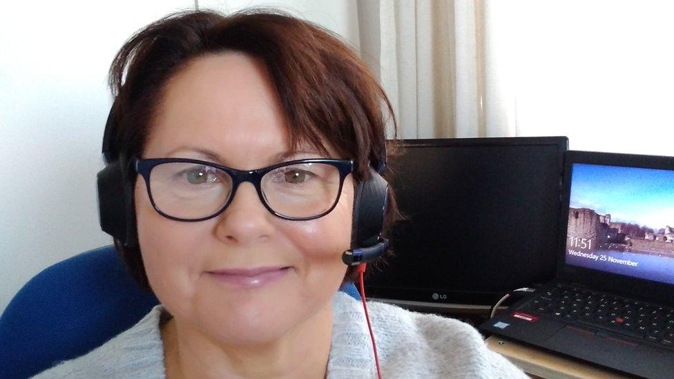 Bridget Thomas wearing a headset at her desk