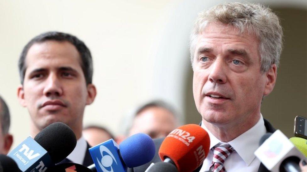 German ambassador to Venezuela, Daniel Martin Kriener (R), speaks to the media as he arrives with Venezuela's self-proclaimed interim president Juan Guaido