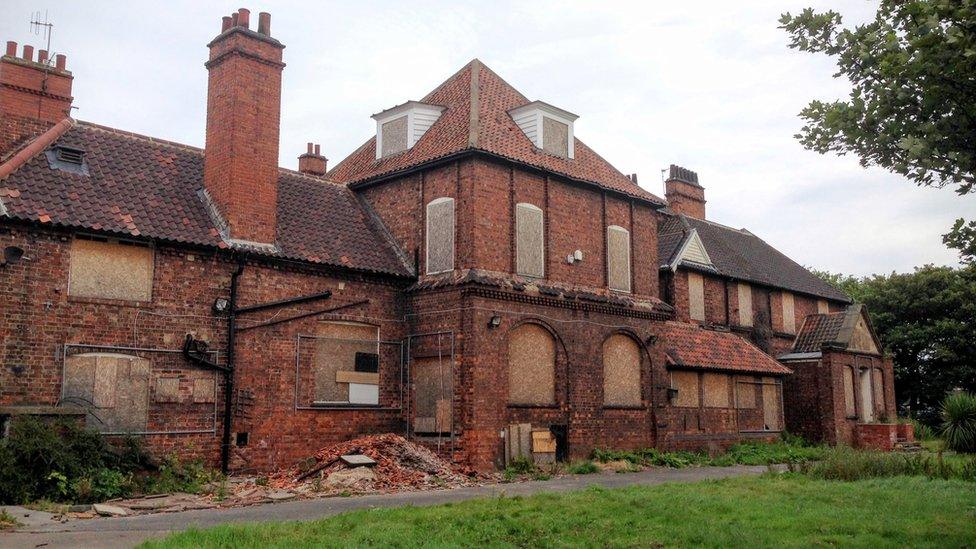 Boarded up red brick building