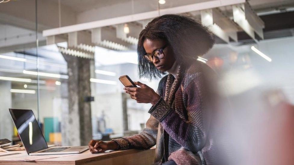 A woman checks her phone