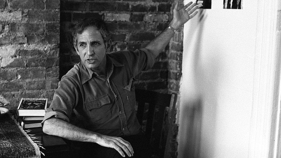 American military analyst and political activist Daniel Ellsberg gestures toward a wall