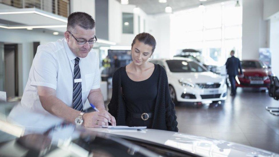 Girls signs papers for a new car