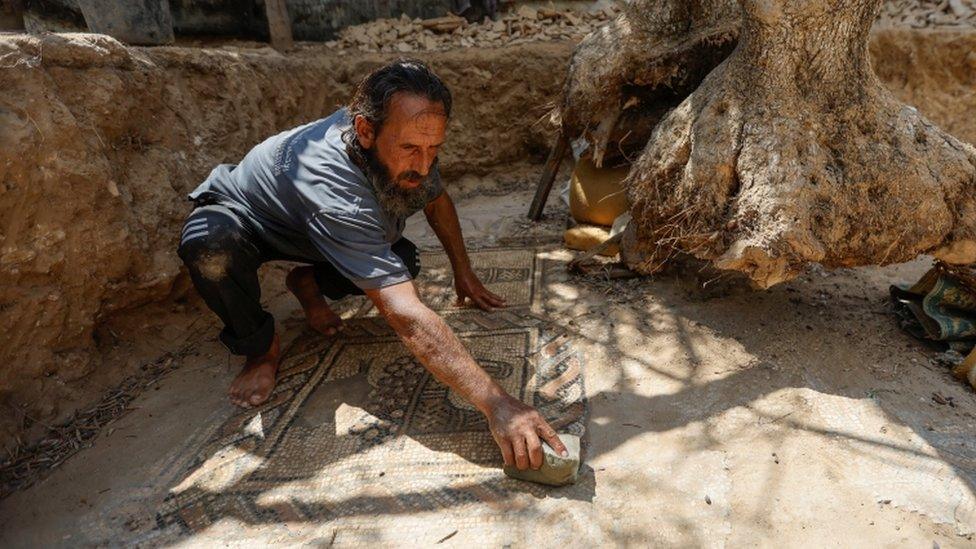 Salman al-Nabahin cleaning the mosaic floor discovered on his farm in Gaza