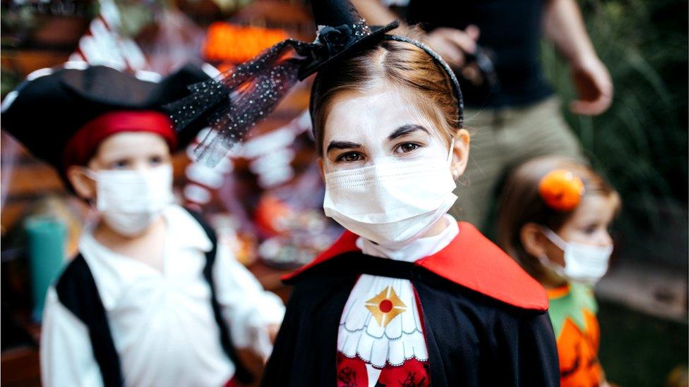 Children dressed for Halloween in face coverings