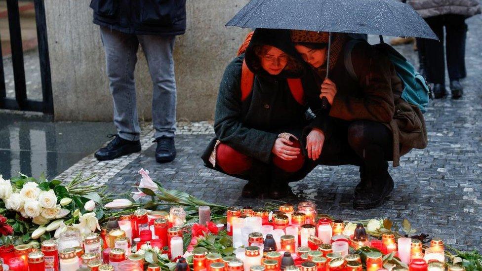 mourners place candles